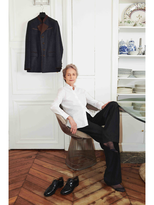 Charlotte Rampling in the studio Rue de Verneuil wearing Autista shirt and pants and The Beaune Jacket hanging on the wall